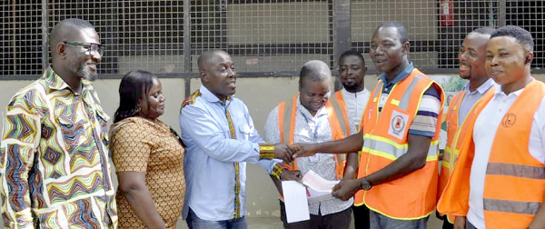 Daniel Boye (3rd from left), Quality Assurance Manager, Panbros, presenting the cheque to Emmanuel Adu-Boahen and his NADMO team