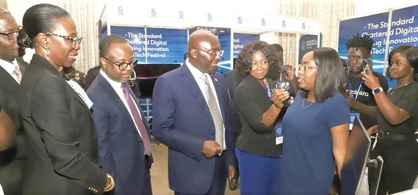 Tracy Oppong-Manu (2nd from right), Founder of the Simpliexpand digital platform, explaining a point about her product to Vice-President Dr Mahamudu Bawumia (3rd from left), during an exhibition mounted at the Standard Chartered Digital Banking Innovation and Fintech Festival in Accra. Those in the picture include Dr Maxwell Opoku-Afari (2nd from left), the First Deputy Governor of the Bank of Ghana, and Mansa Nattey (left), Chief Executive Officer of the Standard Chartered Bank. Picture: GABRIEL AHIABOR