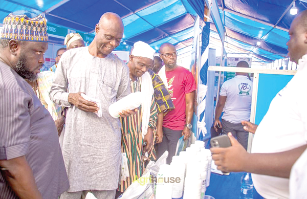 Shani Alhassan Shaibu (2nd from left), the Northern Regional Minister, examining one of the products on display at the exhibition yesterday