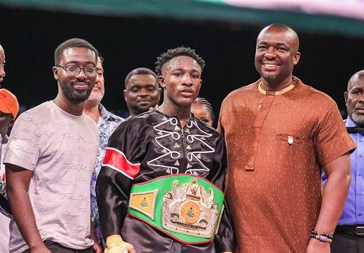 Michael Decardi-Nelson poses with Ghana Boxing Authority President, Abraham Kotei Neequaye (right) and Emmanuel Asamoah, Country Management of Ghana Binance, after being decorated with the title belt