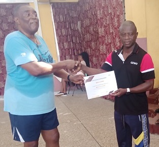 Mr Christopher King (left) presenting a certificate of honour to Mr Christian Aboagye for his feat