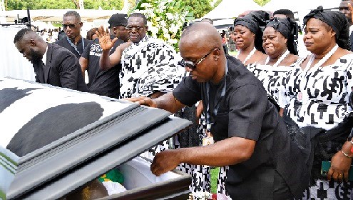 Dr Joseph Siaw Agyepong (left), CEO of Jospong Group, waving goodbye when the casket containing the remains of his father, Opanyin Samuel Kwame Agyepong, was being closed during the burial service at the State House in Accra. With him are some of the siblings
