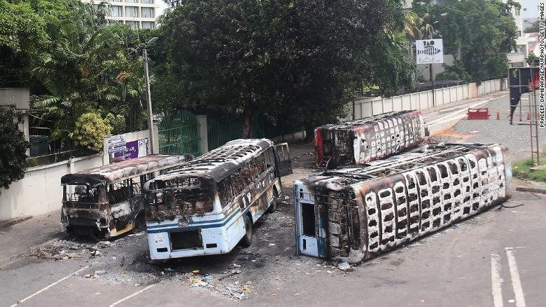Burned buses near the official residence of Sri Lanka's outgoing Prime Minister, Mahinda Rajapaksa, in Colombo, a day after they were torched by protesters on May 10.