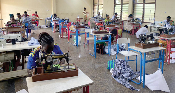 Some of the artisans taking their NVTI examination. INSET: Dr Dominic Eduah, Executive Director of GNPC Foundation 