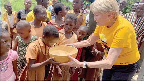 Karen Flewelling (right) giving water fetched from the borehole in a calabash to a pupil to drink after commissioning it