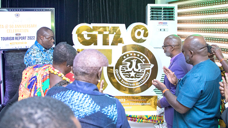   Dr Ibrahim Mohammed Awal (left), the Minister of Tourism, being assisted by some officials to unveil the GTA 50th Anniversary logo