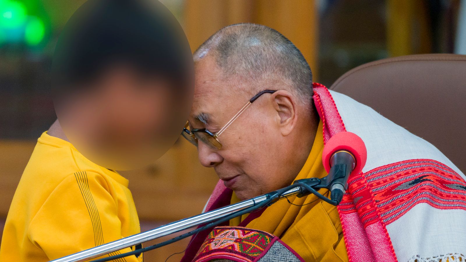 The Dalai Lama touches heads with the young boy. Pic: AP
