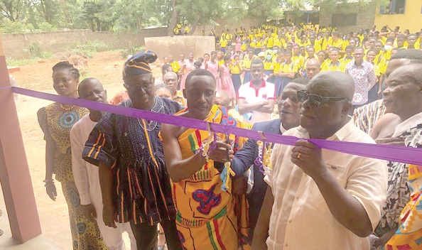 • Nana Boateng Debrah (arrowed), the Chief of Apeguso, being assisted by Samuel Kwame Agyekum, the DCE for Asuogyaman, to cut the tape to inaugurate the project at Apeguso