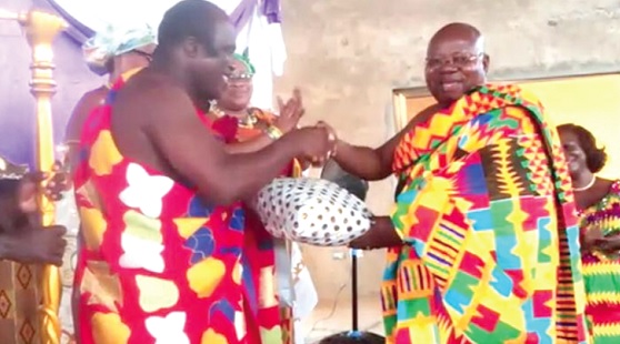 • Osagyefo Kwamena Akonu (left),  Paramount Chief of the Enyan Abaasa Traditional Area, presenting gifts to Dr John Kofi Mensah, MD of ADB