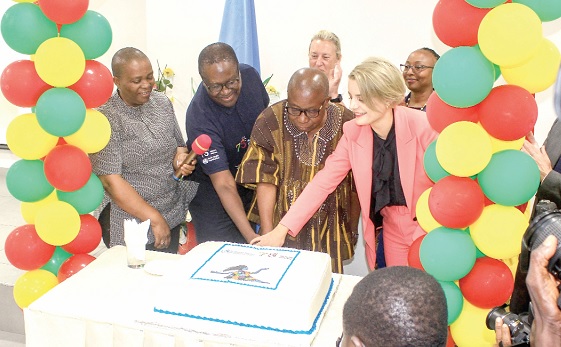 • Kwaku Agyeman-Manu (in smock), Minister of Health, being assisted by Simone Giger (right), Swiss Ambassador to Ghana, and Dr Francis Kasolo (2nd from left), WHO Country Representative, to cut the WHO 75th Anniversary cake. Picture: ERNEST KODZI