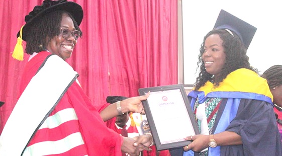 • Herlin Mensah (left), Dean of Students of the Dominion University College, presenting  the certificate to Edinam Be Tina Tefe, the Overall Best Student, at the ceremony
