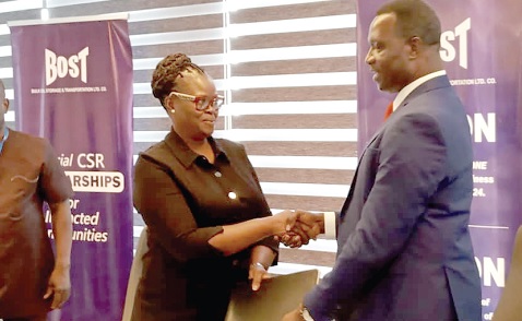 •  Dr Yaw Osei Adutwum (right), Minister of Education, exchanging documents with  Harriet Amoah, the Head of Legal of  BOST