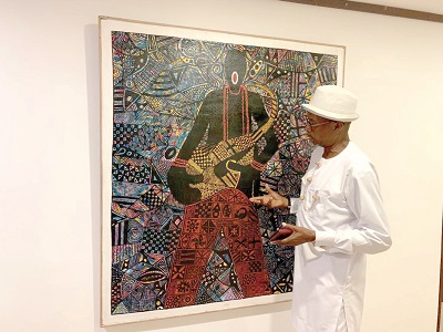 Edward Lamptey, a Creative Art Director at the Edrose Gallery, explaining the concept behind one of his works