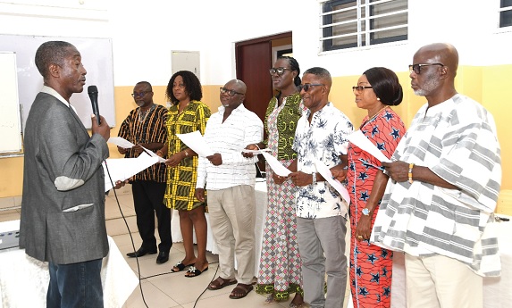 Lawrence Morlemetor Avevor (left), Past President of G-78 of KETASCO and Chairman of the 70th anniversary planning committee, administering the oath to the newly elected executive members of the Keta Old Students Association. Picture: EBOW HANSON