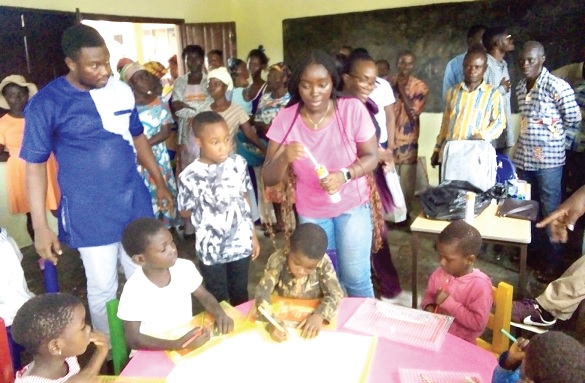 Maame Afua Asabea Yeboah distributing colour pencils to the pupils