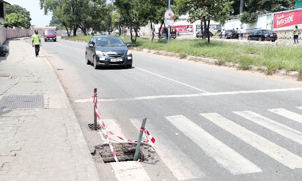 A stolen metal drain cover along the Graphic Road poses  danger to road users. Picture: EDNA SALVO-KOTEY
