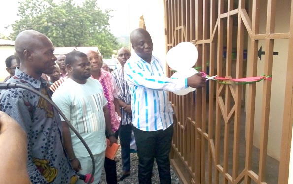 Simon Kweku Tetteh, the Lower Manya Krobo MCE, cutting the tape to hand over the facility to the community