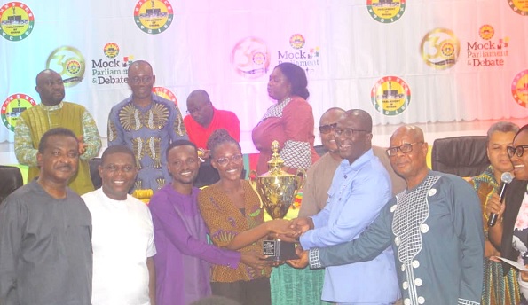 Andrew Asiama Amoako (3rd from right), second Deputy Speaker of Parliament, presenting the trophy to the UCC debate team. With them are some parliamentarians at the programme