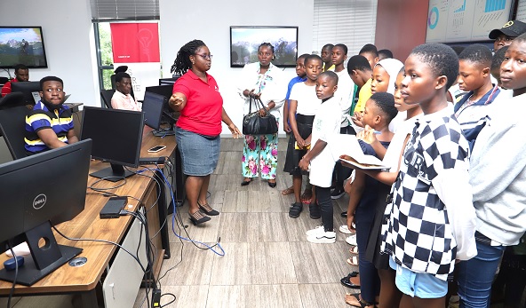 Dorothy Mensah (left),Network Operating Centre Analyst, briefing young girls on ICT skills at the training programme in Accra. Picture: SAMUEL TEI ADANO