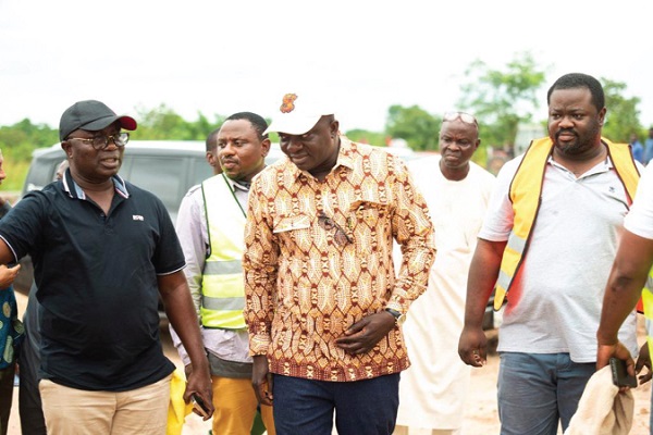Osei Assibey Antwi (left), Executive Director of the NSS, ushering Dr Bryan Acheampong, Minister of Food and Agriculture, and some other dignitaries to take a tour around the farmland