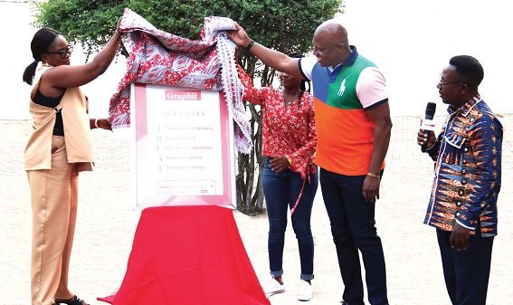 Ato Afful (middle), Managing Director, Graphic Communications Group Limited, being assisted by Yvonne Aryee (left), Senior Corporate Communication Officer, GCGL, to unveil the new core values of the company. Looking on is Emmanuel Arthur (right), Corporate Communications Manager, GCGL. Pictures: ELVIS NII NOI DOWUONA 