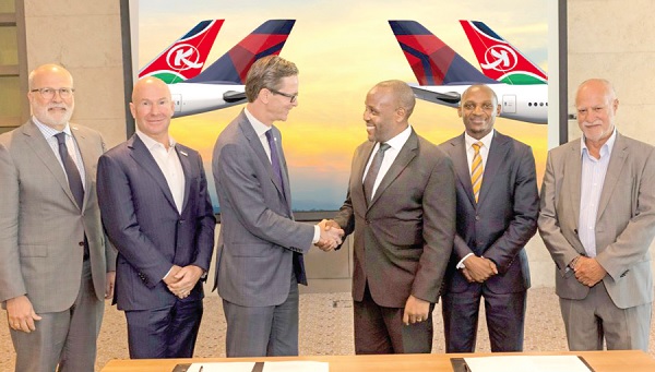 Alain Bellemare (left), President-International, Delta Airlines, in a handshake with Allan Kilavuka, Kenya Airways PLC Chief Executive Officer, while some management staff of both airlines look on