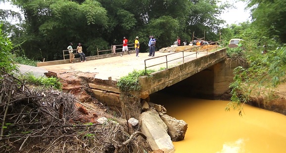The state of the bridge linking Cape-Three-Points and Princess Town in the Ahanta West Municipality which collapsed  during a recent rainstorm. INSET: Rubber expected to be moved to the other side of the Abeasie bridge