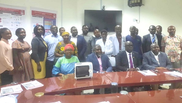 The researchers with the management of KATH during the presentation. On the table is one of the ventilators