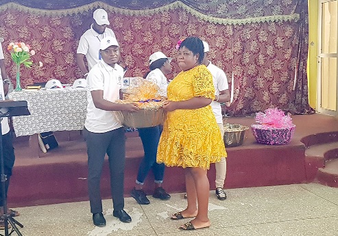 Raphael Ntiri, Director, Universal Aid Dispensation NGO, presenting an item to Leticia Quaye (right), one of the beneficiaries.  Picture: ERNEST KODZI