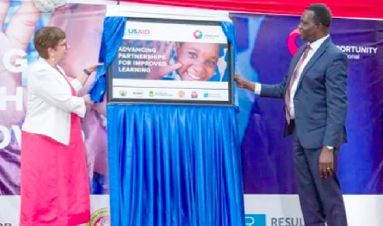Dr Yaw Osei Adutwum (right), Minister of Education, being assisted by Grace Lang, USAID Deputy Mission Director, to launch the project