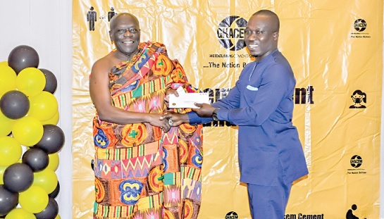 Ehunabobrim Prah Agyensaim VI (left) hands over cement allocation chit to a representative of one of the beneficiary institutions 