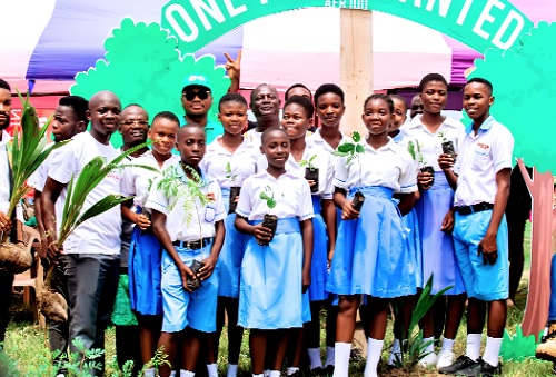 Some of school children displaying tree seedlings they received for the planting exercise