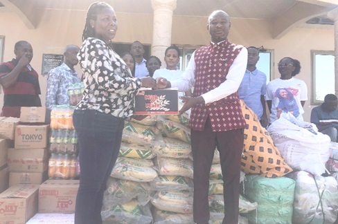 Sena Dake (left), Director of Finance and Administration, Gaming Commission of Ghana, presenting the relief items to Divine Osborne Fenu, District Chief Executive for North Tongu