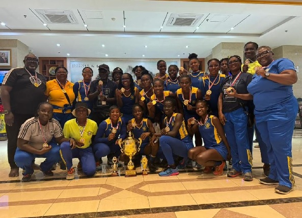 Officials and players of GRA Ladies displaying their trophy and medals won in Malawi