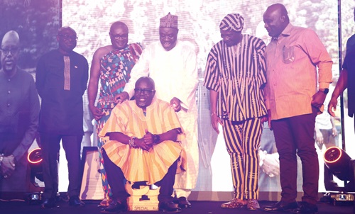Dr Mohammed Ibrahim Awal (middle), Minister of Tourism and Creative Arts, decorating Akwasi Agyemang (seated), Chief Executive Officer, Ghana Tourism Authority, at the event in Accra. With them are some guests and executives of the Ghana Tourism Authority. Picture: SAMUEL TEI ADANO