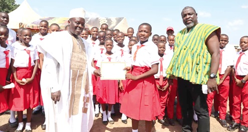 Ahmed Yussuf Abubakar (left), MCE for Yendi, presenting the award to Aniwaba Jessica, School Prefect. INSET: Some of the students on the school farm