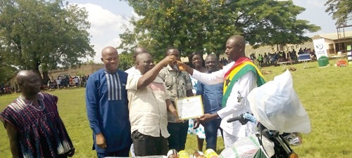 Samuel Kwame Agyekum (2nd from left), the DCE for Asuogyaman, presenting the key to the motorbike to the overall winner, Mohammed Issah of Medissah Variety Farms