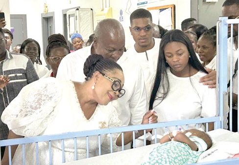 Lordina Mahama (left) with former President John Mahama (arrowed) and their children admiring a new born baby