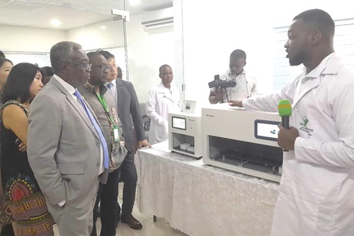 Prince Oti Acheampong (right), Assistant Laboratory Manager, briefing Dr Anthony Nsiah-Asare and other dignitaries after the inauguration