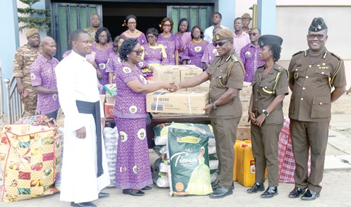 Wilhelmina Graves (3rd from left), Director of Administration, Anglican Diocese of Accra Secretariat, presenting one of the items to Nathaniel Agyemang Onyinah (3rd from right), a Deputy Director of Prisons. With them are Rev. Fr Kwasi Bonsu Asante (left), Programmes Coordinator, Anglican Diocese of Accra Secretariat, other staff of the service and members of the church. Picture: SAMUEL TEI ADANO