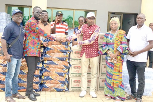 Marlick Adjei (2nd from left), Head of Corporate Communications and External Relations, BOST, presenting the items to Divine Osborn Fenu (3rd from right), the District Chief Executive