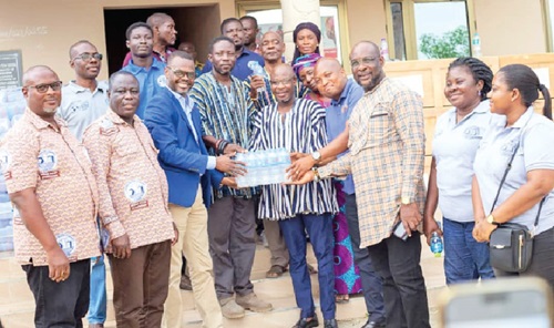 Francis Lamptey (2nd from left), Volta Regional Chief Manager of GWCL, presenting the items to Osborne Fenu (4th from right), North Tongu DCE. With them include Samuel Okudzeto Ablakwa (3rd from right), NDC MP for North Tongu, and Seji Saji, Deputy Director-General of NADMO