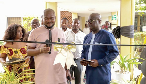 Nana Akwesi Awuah (middle), MD, PMMC, cutting the ribbon to launch the lobby sales