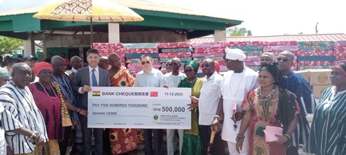 Yang Qun, President of Ghana Chinese Enterprise Chamber of Commerce, handing over a dummy cheque to Abla Dzifa Gomashie, MP for Ketu South. With them isTogbe Afede XIV, Agbogbomefia of the Asogli State, and other officials at the event