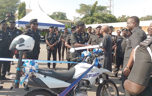 Keli Gadzekpo (arrowed), Board Chairman of ECG, handing over keys to the motorbikes to Dr George Akuffo Dampare, Inspector General of Police