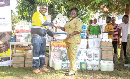 Samuel Noi (left), Process Manager at Ahafo South Mine, presenting items to Charlotte Kessewah Adu-Gyamfi, the District Health Director for Asutifi North