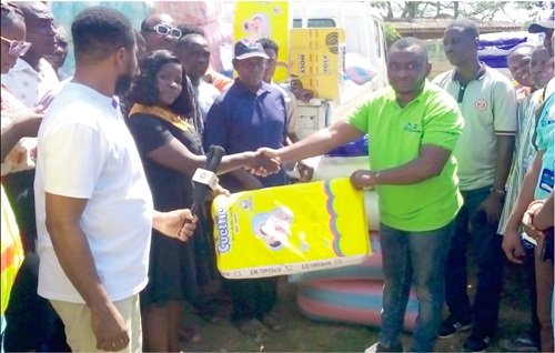 Applause Ebenezer Sedzifa (third from left), Divisional Secretary of the VRA Union of TUC, presenting an item to one of the victims at Dorfor Adidome 