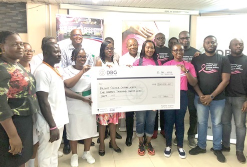 Barbara Wricketts (3rd from right), CSR Lead of DGB, presenting a dummy cheque for GH¢100,000 to Dr Josephine Nsaful (4th from left), the General Surgeon, Breast Surgery Unit of KBTH