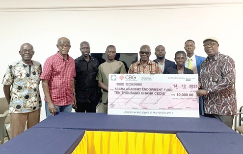 Laud Senanu (right), Trustee and Legal Advisor of the BLFI, presenting the cheque to Nii Quansah Abbey Ashong (5th from right), Secretary of the Endowment Fund, while other old boys and dignitaries look on