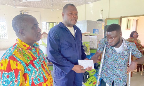 Ernest Victor Apau (middle), Ho West DCE, presenting an amount of money to Isaac Abor, a computer science student of the Ho Technical University, while Roland Kumfo, the District Director of Social Welfare, looks on